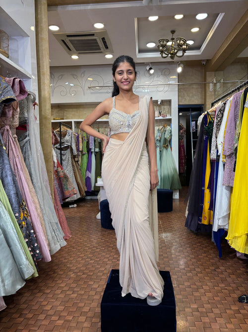 Beige Lycra saree with hand embroidered blouse.
